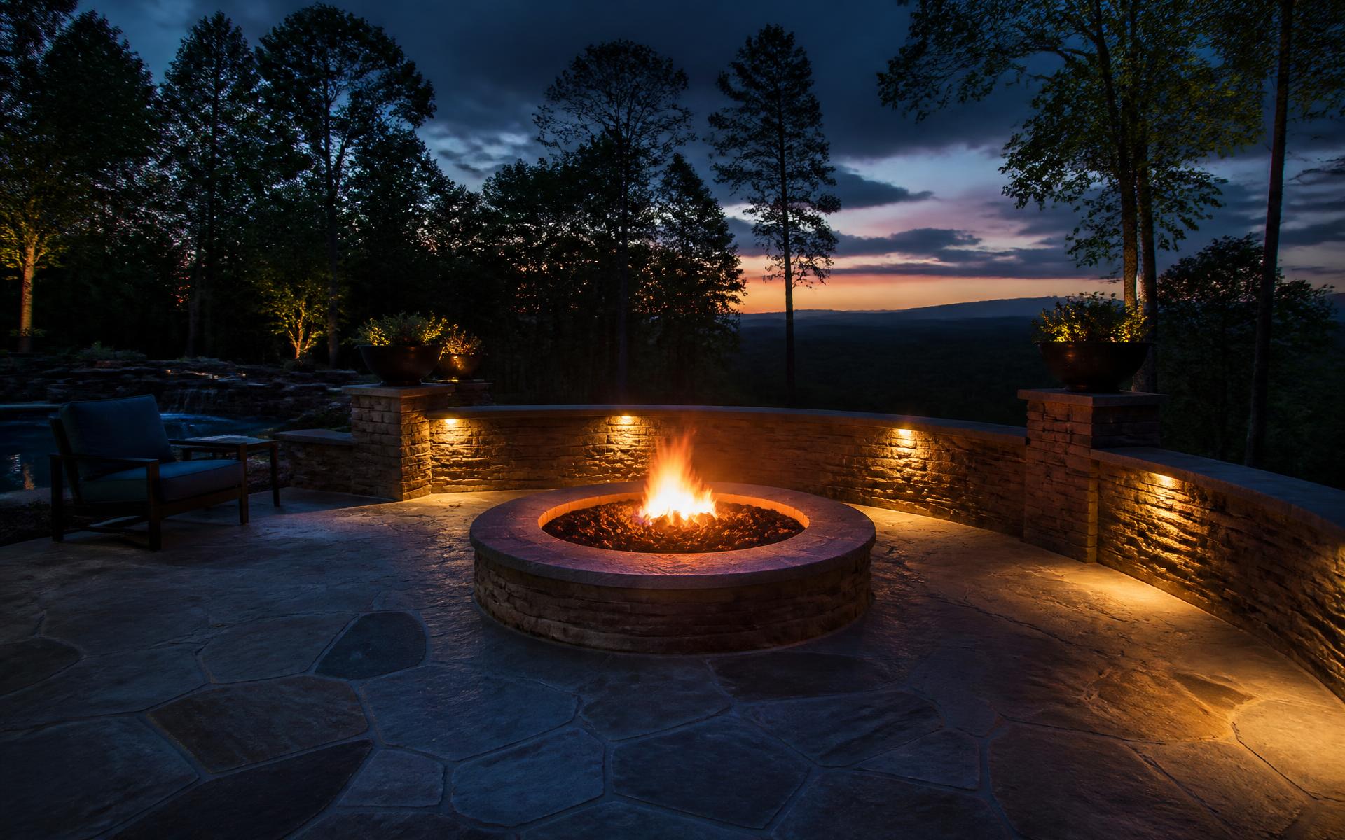 Dusk view of a flagstone patio with stone fire pit and retaining wall built by Sierra Hardscape LLC in Reno, Nevada